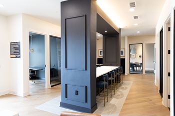 A modern kitchen with a tall dark blue cabinet and a white countertop at The Crest at South Point Apartments, Georgia